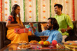 © IndiaPix - Friends opening gift during Diwali celebration