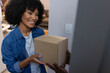 © Wavebreak Media - Happy biracial woman receiving parcel at home