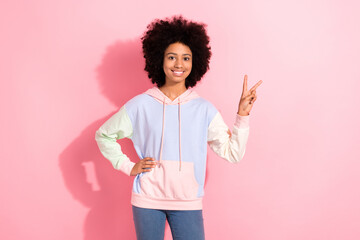 Poster - Portrait of cheerful cute girl toothy smile hand fingers demonstrate v-sign hello greeting symbol isolated on pink color background