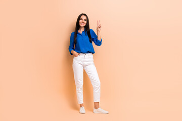 Sticker - Full length photo of positive glad lovley lady wear trendy blue clothes showing hand v-sign good mood isolated on beige color background