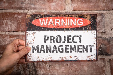 Wall Mural - Project Management Concept. Warning sign with text in the hands of a woman