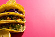 High angle view of tacos with lemon slices against pink background, copy space