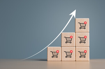 Wooden cubes with shopping cart icons and increasing trend-up graph. Increase higher sale volume and shopping trolley cart for online ecommerce business and internet  marketing strategy concept.