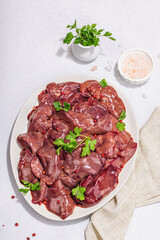 Wall Mural - Raw chicken liver on stone background. Fresh ingredients ready for cooking, parsley, red pepper