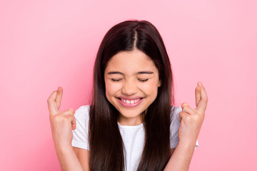 Wall Mural - Photo portrait of adorable schoolkid female crossed fingers hope lottery dressed stylish white clothes isolated on pink color background