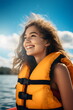 © Ricky - Happy teen girl on boat wearing orange life jacket