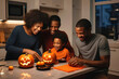Happy family, father and children are preparing to celebrate Halloween. Making holiday decorations.