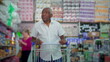 © Marco - One senior black shopper pushing shopping cart at grocery store, browsing products on shelves depicting consumer lifestyle habbits