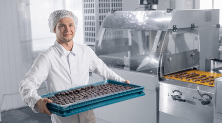 Wall Mural - Chocolate candies process making master factory worker. Concept modern food industry production line
