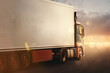 lkw fährt schnell auf autobahn mit sonnenstrahlen am horizont im abendrot