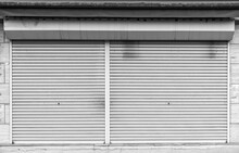 Closed Steel Shutter Door Of Warehouse, Storage Or Storefront For Metal Door Background And Textured.