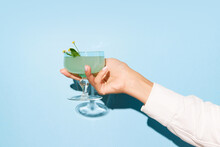 Women Hand Holding Glass With Margarita Cocktail On Light Blue Pop Art Background. Copy Space For Ad.