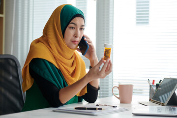 Wall Mural - Portrait of mature muslim project manager calling her doctor to discuss effect of new antidepressant