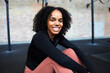 © Flamingo Images - Smiling woman sitting on a gym floor
