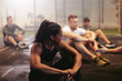 © Flamingo Images - Fit woman sitting with her exercise class in a gym