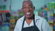 © Marco - Happy Portrait of Brazilian Senior Supermarket Staff Holding Tablet, Joyful Older Male Employee in Apron