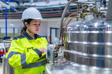 Asian engineer working at Operating hall,Thailand people wear helmet  work,He worked with diligence and patience,she checked the valve regulator at the hydrogen tank.