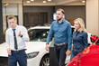 © Михаил Решетников - Happy caucasian couple choosing a new car in a car dealership.