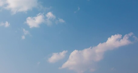 Wall Mural - Cloud blue sky background Time lapse Beautiful white clouds approach the point of view backed by a vivid blue sky in this one minute loop Time lapse raw photo interval at 1 second fade at video's end
