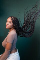 Wall Mural - Beautiful young woman, sitting sideways, with braids of her hair flying.