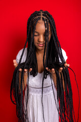 Wall Mural - Beautiful young woman holding her long braids with her hands.