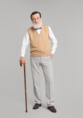 Poster - Senior man with walking cane on light gray background