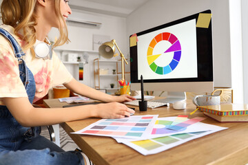 Female graphic designer working with computer at table in office, closeup