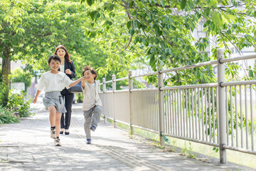 Wall Mural - 歩道を笑顔で歩く親子　child walking on sidewalk