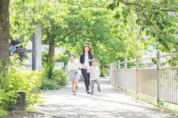 Wall Mural - 歩道を笑顔で歩く親子　child walking on sidewalk