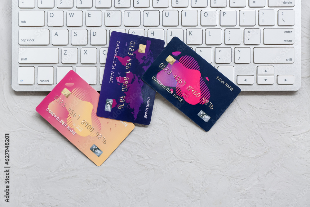 Keyboard with different credit cards on grunge grey background