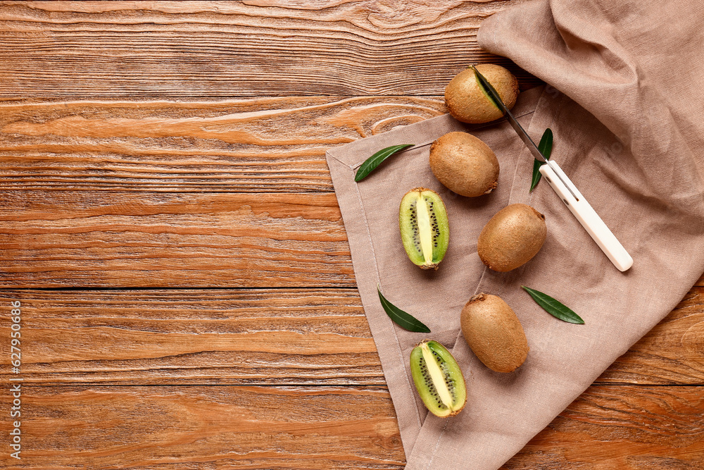 Fresh kiwi and leaves on wooden background