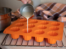 Pouring The Liquid Batter In The Silicone Ridged Fluted Mold Before Baking. Making French Canele Pastries