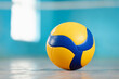 Volleyball blue and yellow ball on the floor in the gym. Concept of sport training, physical improvement, active way of life