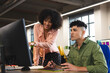 © Wavebreak Media - Happy diverse female and male colleagues in discussion at computer in office