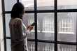 © Wavebreak Media - African american businesswoman using a smartphone near a window at modern office, copy space