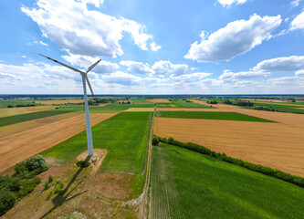 Panoramic view of wind farm or wind park, with high wind turbines for generation electricity with copy space. Green energy concept.