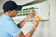 © Malik/peopleimages.com - Air conditioner, meter and electrician man for ac repair, maintenance and electrical power services on fan system. Person, technician or contractor with electricity, box check and hvac engineering