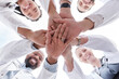 © Nadia L/peopleimages.com - Hospital doctors, happy people and circle hands together for healthcare teamwork, medical team building and clinic celebration. Solidarity, below view and group surgeon for collaboration success