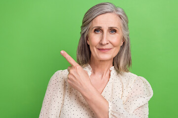 Sticker - Photo of candid sincere person with gray hairstyle dressed elegant blouse indicating empty space sale isolated on green color background