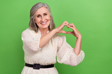 Poster - Photo of sweet adorable lady wear beige dress showing arms fingers heart isolated green color background