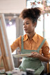 © Natee Meepian - Young artist beautiful american african working in her painting studio