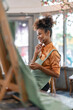 © Natee Meepian - Young artist beautiful american african working in her painting studio