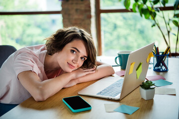 Wall Mural - Photo of young girl brown bob hair lying wooden desktop near window office manager waiting for customers with laptop indoors background