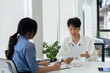 © itchaznong - employee discuss business income report together in the office