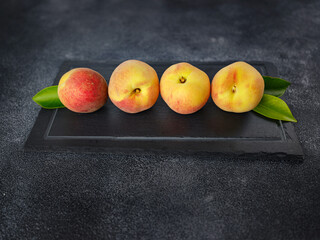 Wall Mural - Harvest of peaches for food or juice. fresh organic fruit, vegan food. Large peaches on dark table background, selective focus.