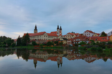 Canvas Print - Scenic morning cityscape of medieval town of Telc in the Czech Republic. The castle and colorful buildings reflected in calm water in the lake. Travel and tourism concept. UNESCO World Heritage Site