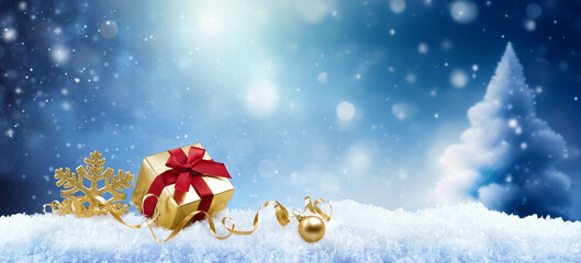 Wall Mural - christmas background with a golden gift, a snowflake and a ball in the snow in forest against a blue