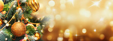 Christmas Tree With Gold Baubles Close-up Against Backdrop Of Golden Sparkling Christmas Lights. Wide Format Banner. Background With Atmosphere Of Celebration And Magic.
