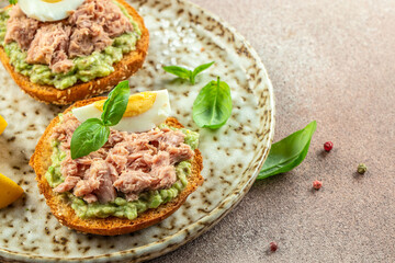 Wall Mural - Tuna sandwich with avocado and boiled egg on plate. Food recipe background. Close up