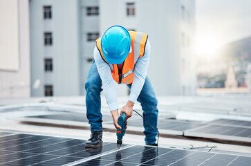 Canvas Print - Engineer man, drill and solar panel on roof with industry, sustainability or construction in city. Technician, power tools and photovoltaic system for building, development or renewable energy in cbd